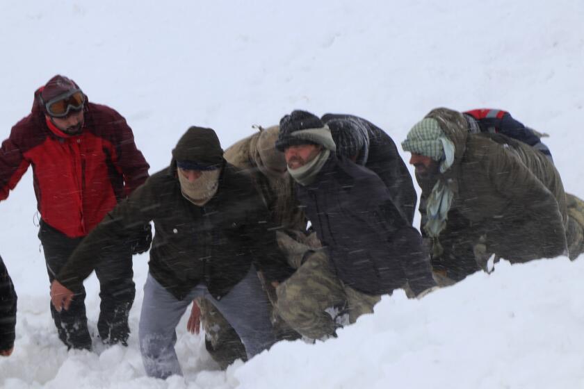 Emergency service members carry a victim of an avalanche, near the town of Bahcesaray, in Van province, eastern Turkey, Wednesday, Feb. 5, 2020. An avalanche slammed into a mountain road in the province, which borders Iran, wiping out a huge team of rescue workers sent to find two people missing in an earlier avalanche. (Feyat Erdemir/DHA via AP)