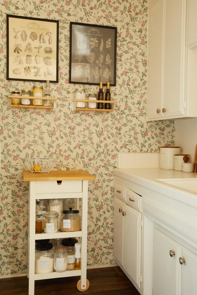 A white kitchen with floral wallpaper