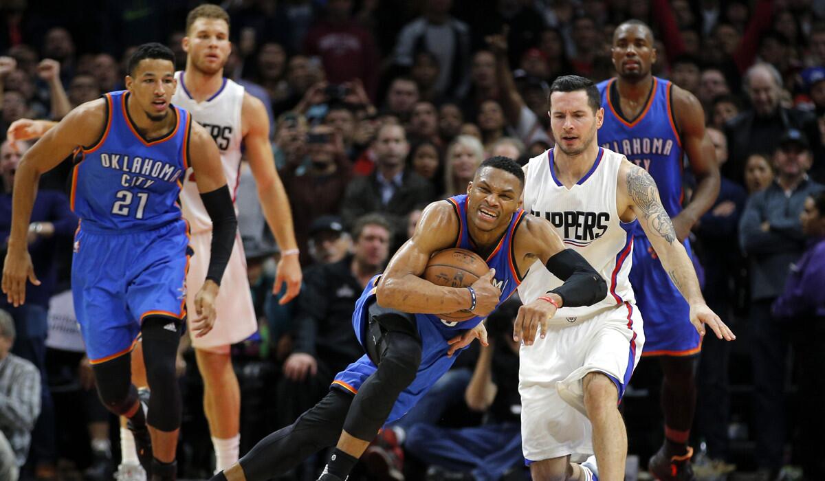 Oklahoma City Thunder's Russell Westbrook, center, gets a loose ball against the Clippers' J.J. Redick, right, during the second half Monday.