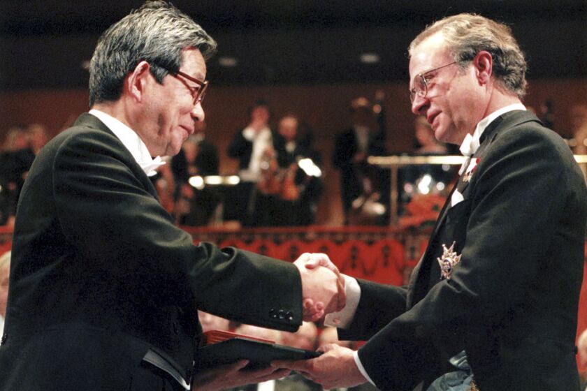 FILE - Japanese Kenzaburo Oe, left, receives the Nobel Prize for Literature from Swedish King Carl XVI Gustaf, right, at the Concert Hall in Stockholm Sweden, Dec. 10, 1994. Japanese publisher Kodansha Ltd. said Monday, March 13, 2023 that Nobel literature laureate Kenzaburo Oe died of old age. Oe's darkly poetic novels were built from a childhood during Japan’s postwar occupation and parenthood with a disabled son. (AP Photo/Gunnar Ask, File)