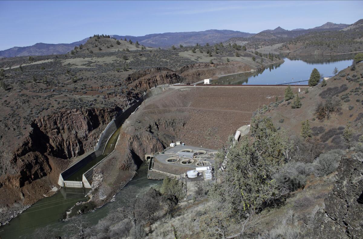 A dam and reservoir sit amid a dry landscape