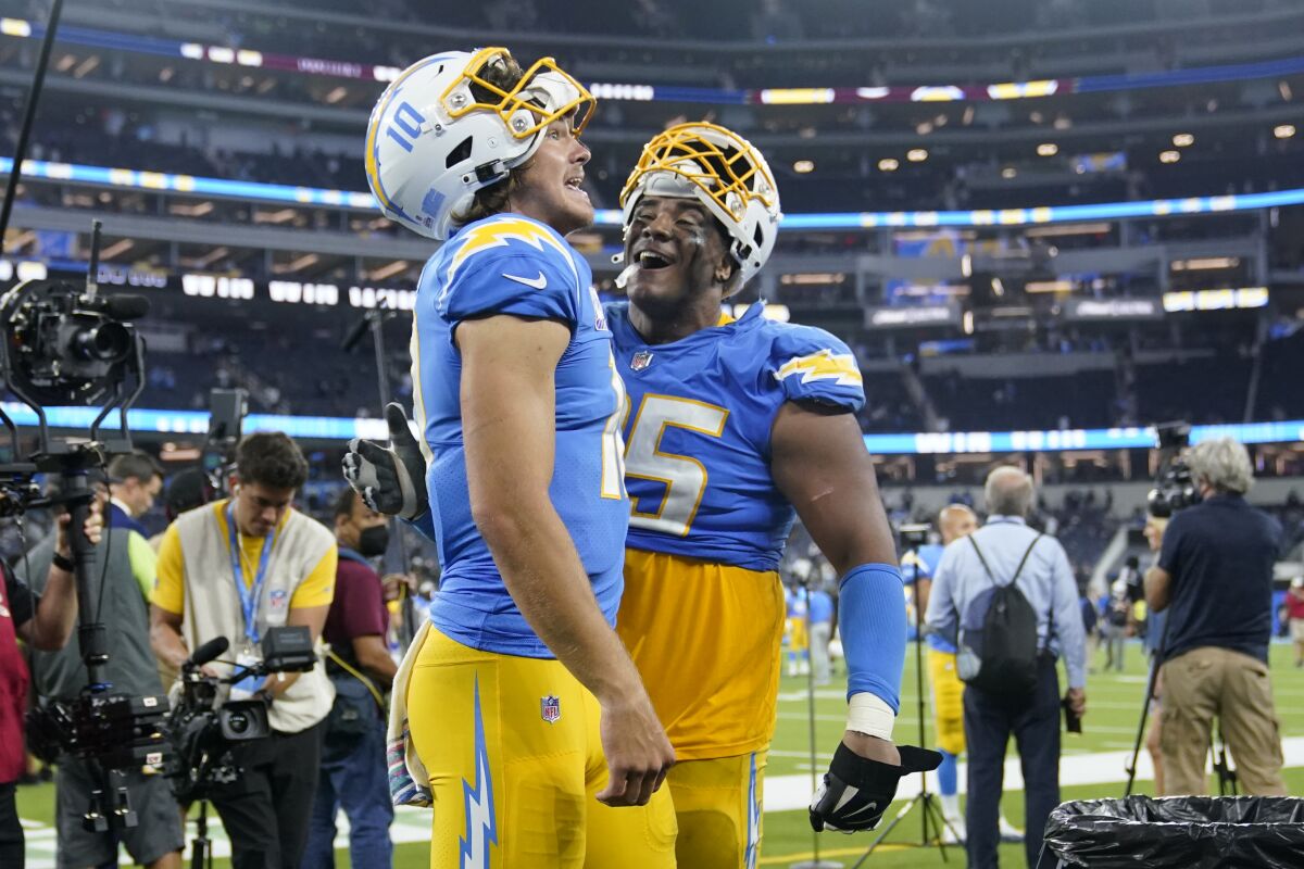 Los Angeles Chargers quarterback Justin Herbert, left, and running back Larry Rountree III celebrate after the Chargers defeated the Las Vegas Raiders 28-14 in an NFL football game Monday, Oct. 4, 2021, in Inglewood, Calif. (AP Photo/Marcio Jose Sanchez)