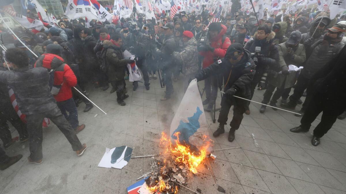 A protester burns a Korean unification flag during a rally in Seoul on Feb. 11, 2018, protesting North Korea's participation in the 2018 Pyeongchang Winter Olympics.