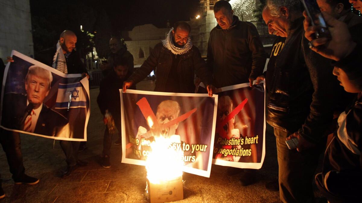 Palestinian protesters burn pictures of President Trump at manger square in Bethlehem on Dec. 5, 2017.