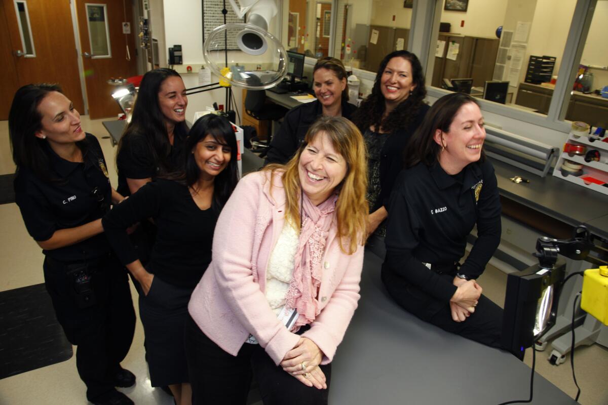 Team members, from left, Christina Pino, Gabrielle Wimer, Krishna Patel, Carrie Harris, Nicole Salim and Tina Bazzo share a light moment with their boss, Donna Brandelli, foreground in pink. Brandelli was brought in to jump-start the civilian unit in 2010 and has assembled an all-woman team that handles all of the forensic work for the Torrance Police Department.