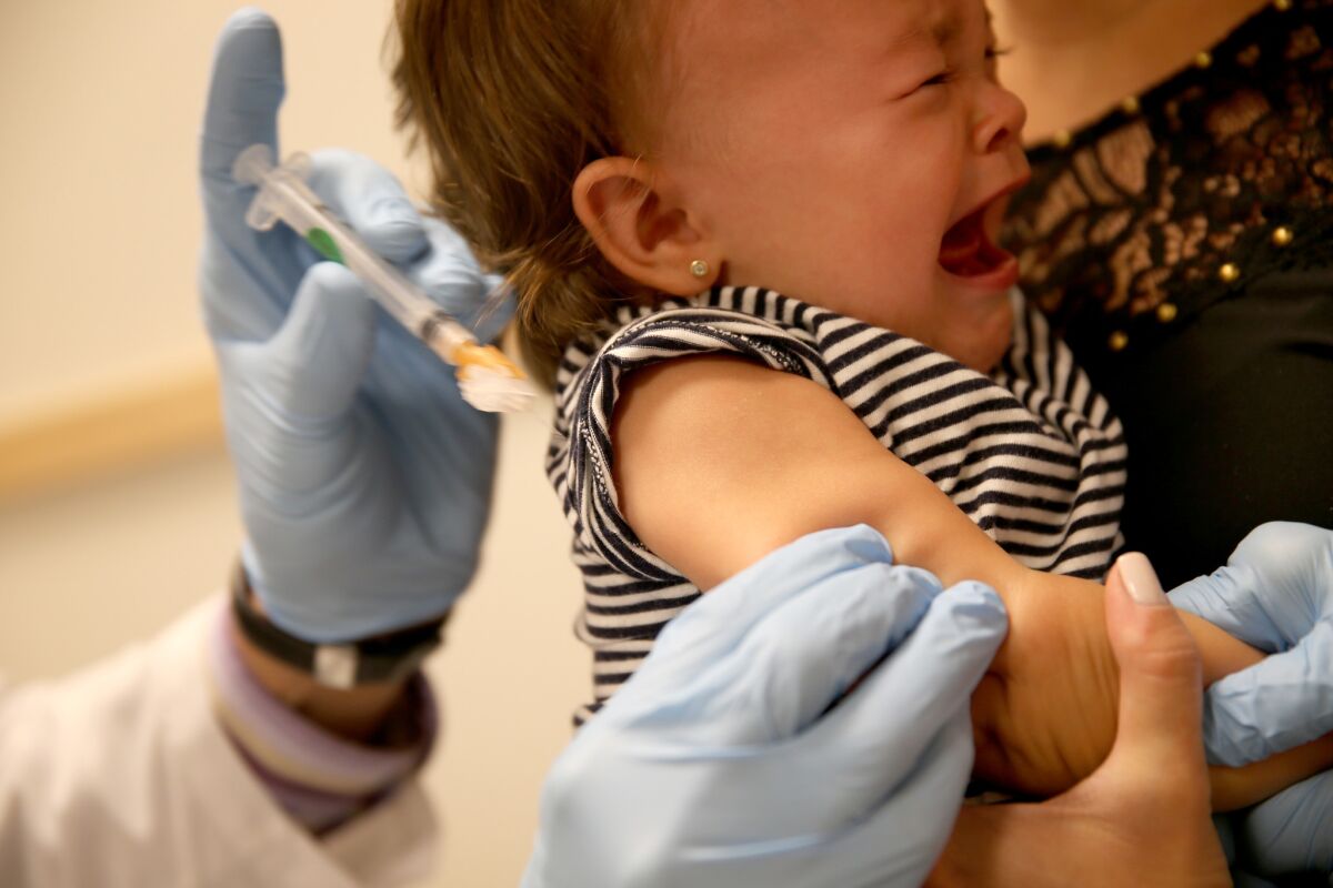 Daniela Chavarriaga holds her daughter as pediatrician Jose Rosa-Olivares administers a measles vaccination during a visit to the Miami Children's Hospital. There are still millions of children around the world who don't have access to the measles vaccine.