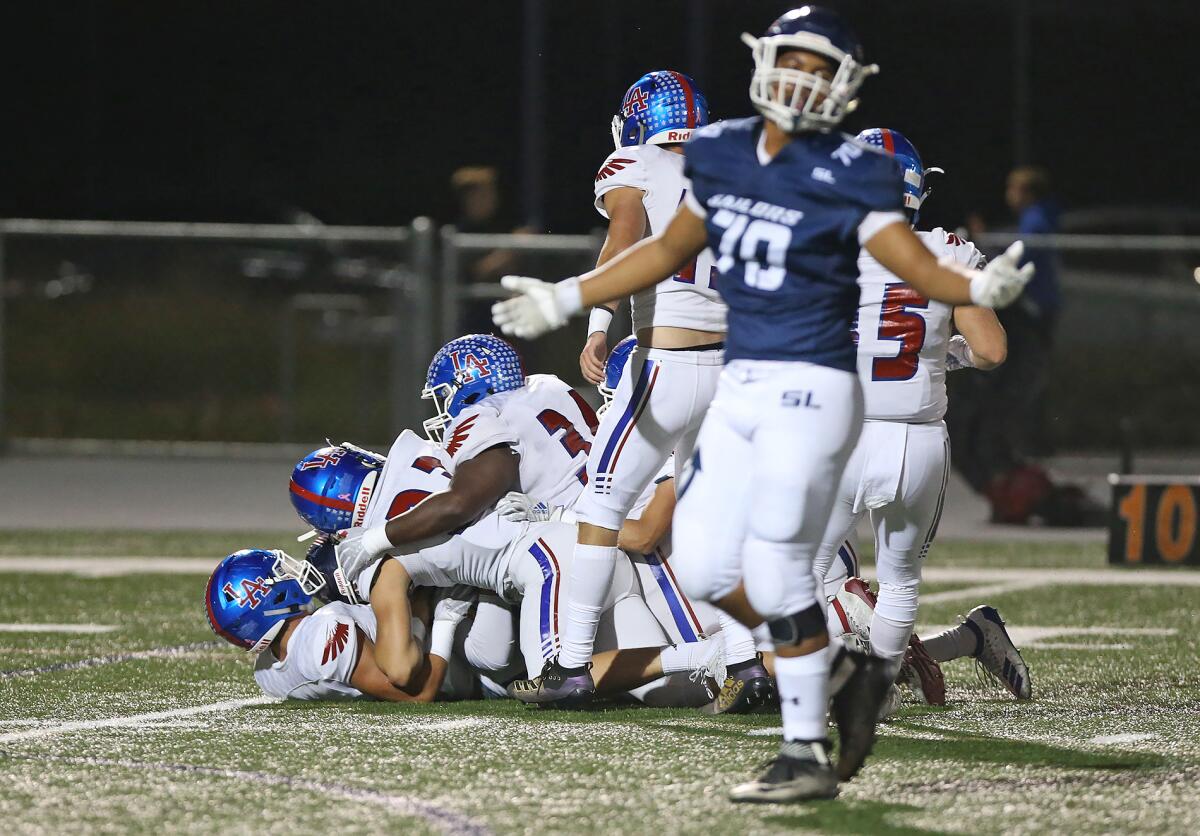 Newport Harbor lineman Grayson Simon (70) throws his hands up after a host of Los Alamitos players sack quarterback Nick Kim in a Sunset League game on Friday at Davidson Field.