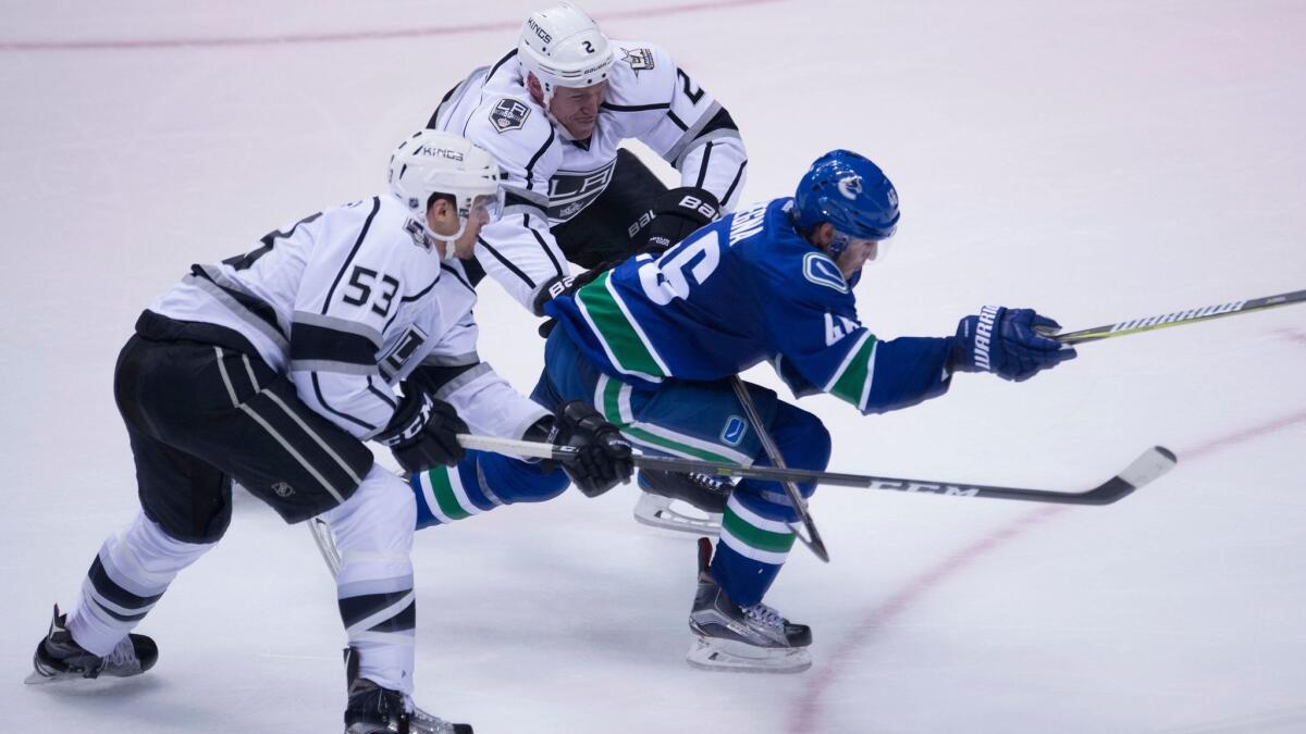 Kings defensemen Kevin Gravel, left, and Matt Greene try to slow Vancouver's Jayson Megna on Dec. 28.