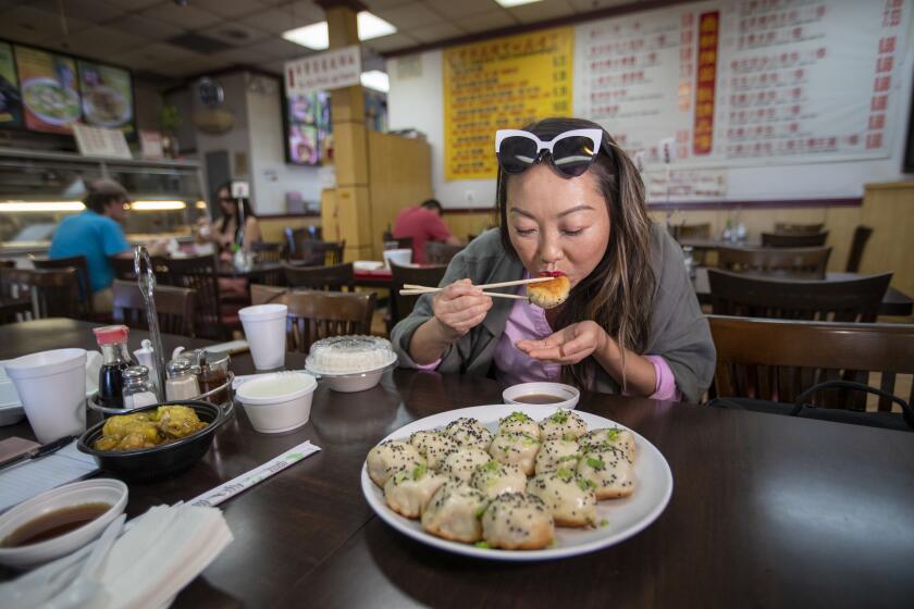ALHAMBRA, CALIF. -- SUNDAY, JULY 28, 2019: Lulu Wang samples a plate of sheng jian bao at the Kang Kang Food Court in Alhambra Sunday, July 28, 2019. Director and writer Lulu Wang, whoÕs recent movie, the Farewell, talks about the role food plays in the movie. (Allen J. Schaben / Los Angeles Times)