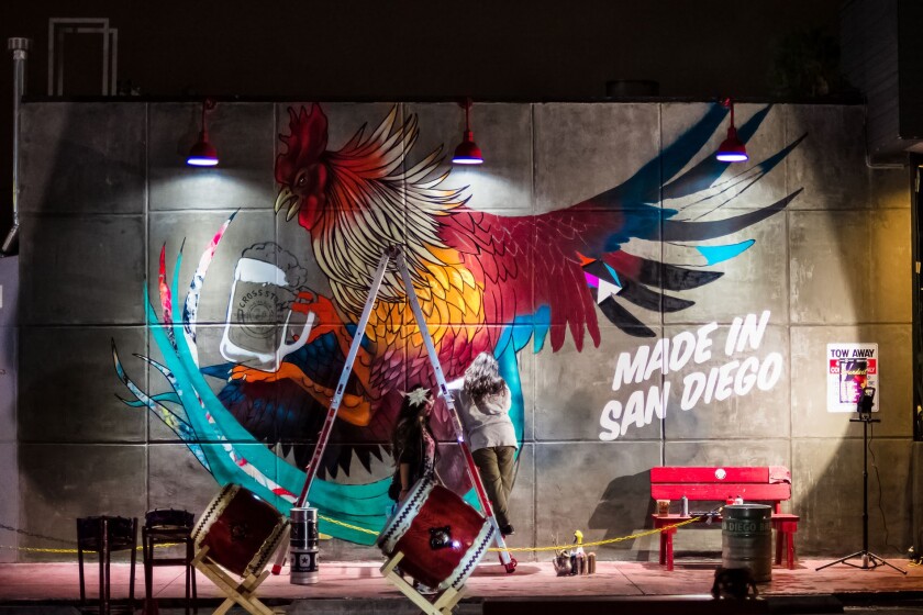 Mural of a chicken next to the words made in San Diego being painted on a wall in the Convoy district.