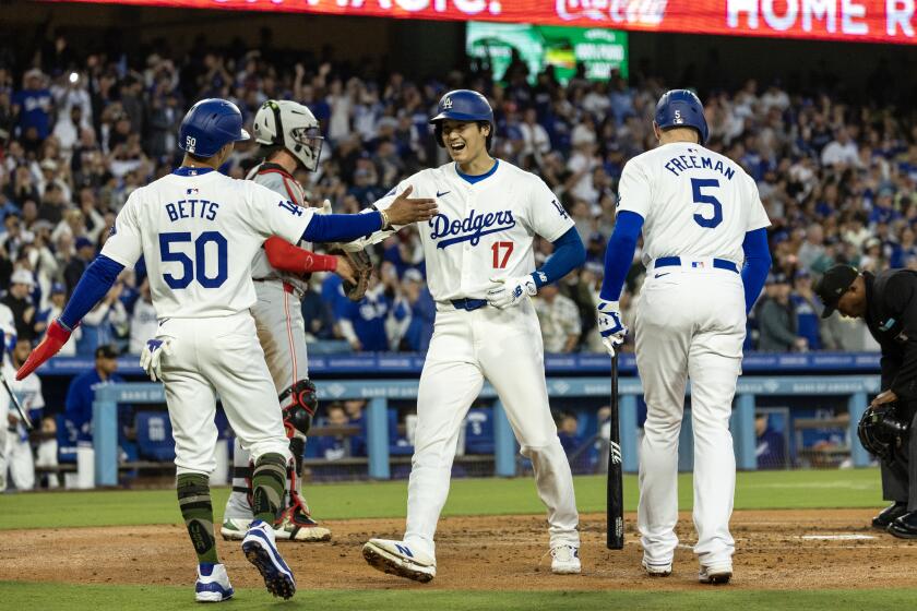 Dodgers star Shohei Ohtani is greeted by Mookie Betts and Freddie Freeman after hitting a two-run homer 