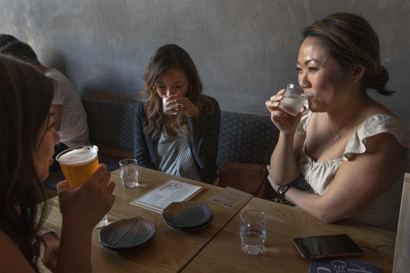 ECHO PARK, CA-AUGUST 16, 2019: Left to right-Joyce Yu, Cat Yeh, and Becky Chuen sip their drinks while dining at Ototo, a sake bar in Echo Park. (Mel Melcon/Los Angeles Times)