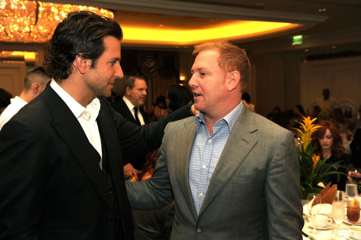Ryan Kavanaugh, pictured here with Bradley Cooper in 2012, is unable to make payments on $320 million in debt and has started layoffs at Relativity Media.