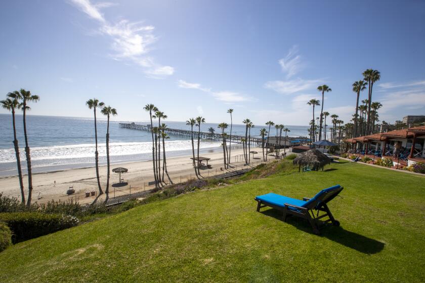 SAN CLEMENTE, CA -- FRIDAY, APRIL 24, 2020: An empty lounger at the Beachcomber Inn with a scenic view of an empty, closed beach and pier due to coronavirus pandemic social distancing restriction amid a heat wave at San Clemente beach in San Clemente, CA, on April 24, 2020. In San Clemente the local council voted to reopen the beach for recreational activity such as walking, running, swimming and surfing, but have also said residents should not bring a blanket and hang out starting Saturday morning at 6am. The city is attempting to limit access to local residents by keeping parking lots closed, and other Orange county officials have urged out-of-town residents not to visit the beaches and parks that remain open. (Allen J. Schaben / Los Angeles Times)