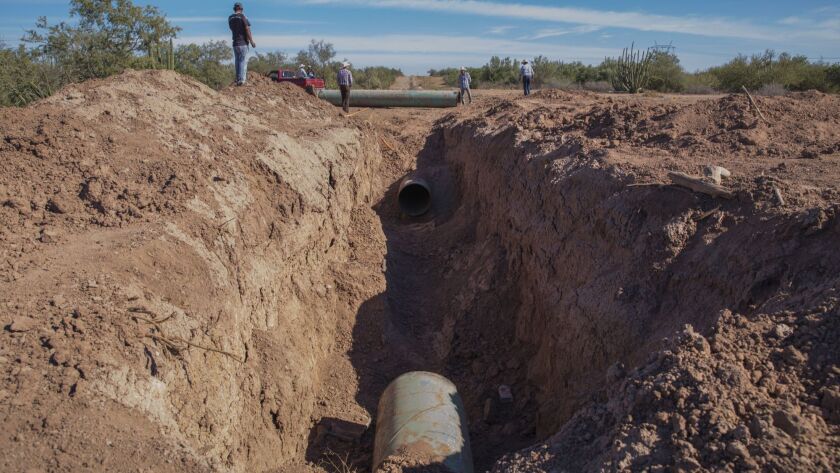 Members of the Yaqui comunity of Loma de Bacum look at the site where locals removed a 25-foot chunk from a natural gas pipeline project owned by IEnova, the Mexican subsidiary of San Diego-based Sempra Energy.