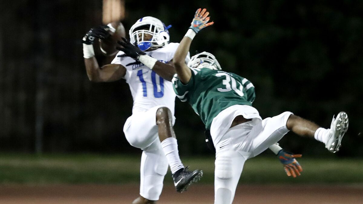 Culver City wide receiver Alexander Smith (10) makes in a leaping catch near the end zone against Dorsey defensive back Jair Lindo during the second quarter Friday night.