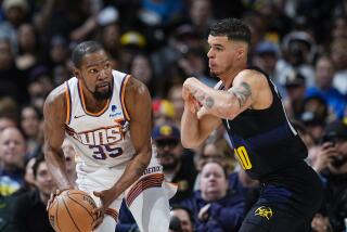 Kevin Durant, alero de los Suns de Phoenix, busca avanzar frente a Michael Porter Jr., de los Nuggets de Denver, en el duelo del miércoles 27 de marzo de 2024 (AP Foto/David Zalubowski)
