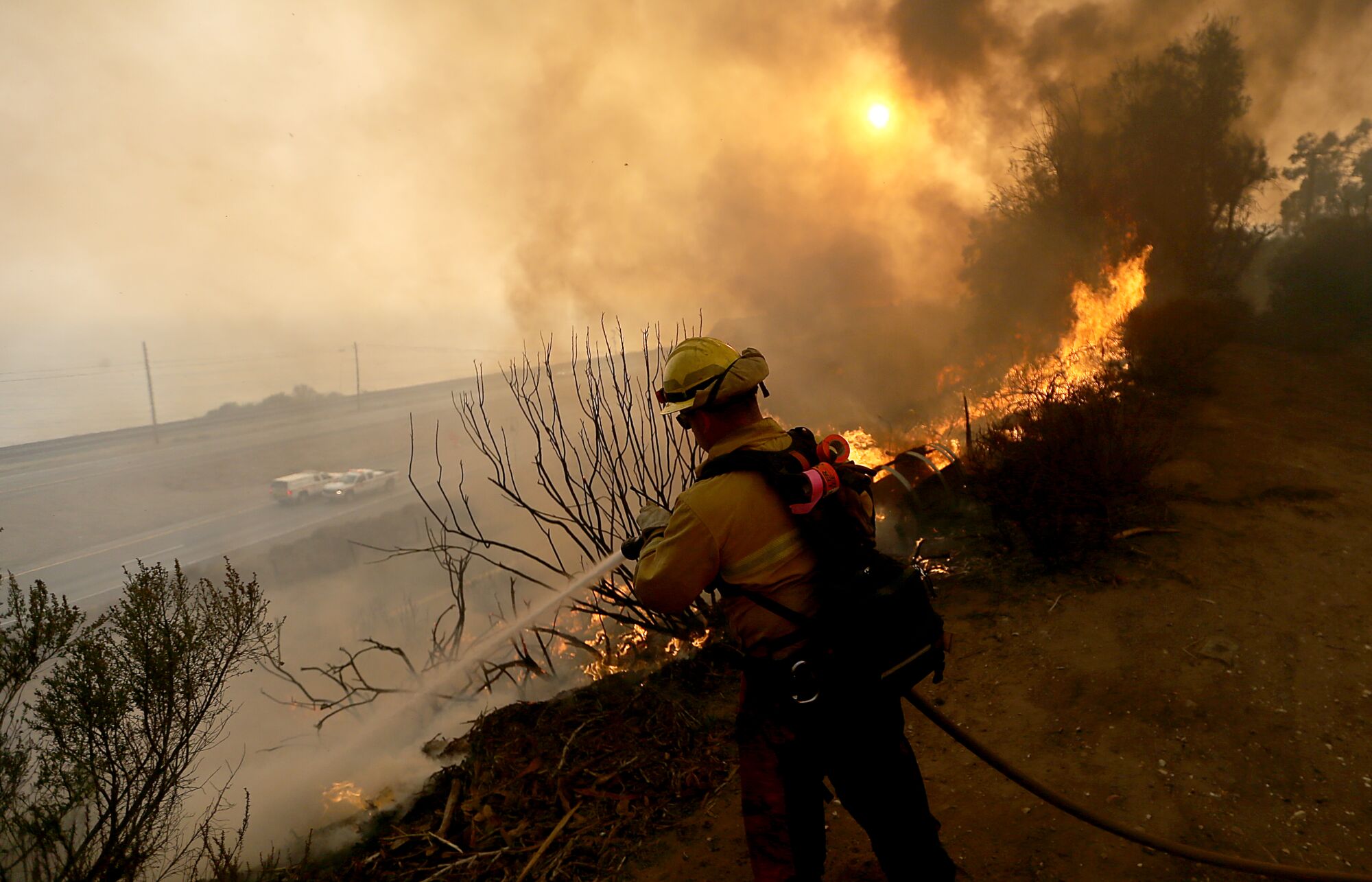 A firefighter battles the Alisal fire along the 101 Freeway near Goleta on Tuesday.