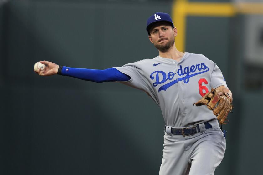 Los Angeles Dodgers shortstop Trea Turner thorws to first base to put out Colorado Rockies' Yonathan Daza.