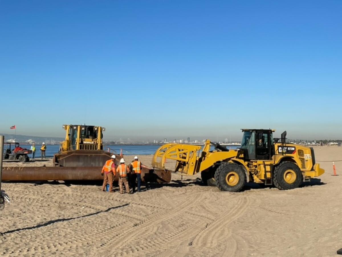 Trucks are out mid-beach in Surfside Colony on Monday, where dredging is taking place.