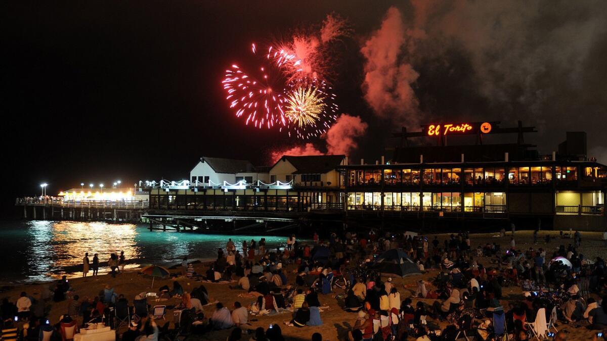 Spectators watch the fireworks light up the sky over Redondo Beach Pier on July 4.
