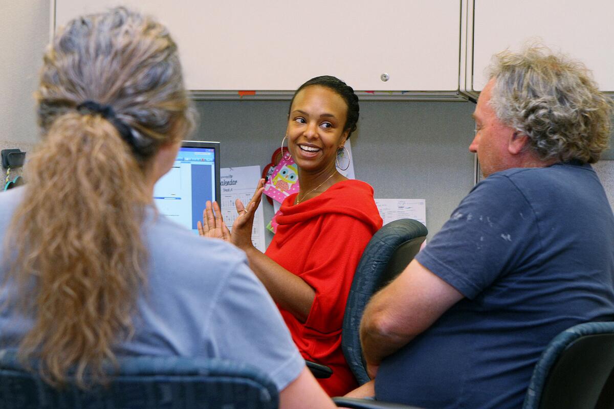 Rasheedah Scott, a case worker with the Community Services & Parks Verdugo Job Center, talks with siblings Jo Marie and Craig McKenzie, of Los Angeles, about Covered California coverage that they are interested in applying for on Friday, March 14, 2014. Scott's daily schedule is filled with approximately hour-long appointments to talk with people about Covered California.