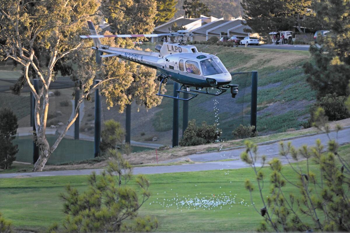 An LAPD helicopter drops golf balls over the course at the La Cañada Flintridge Country Club on Oct. 27.