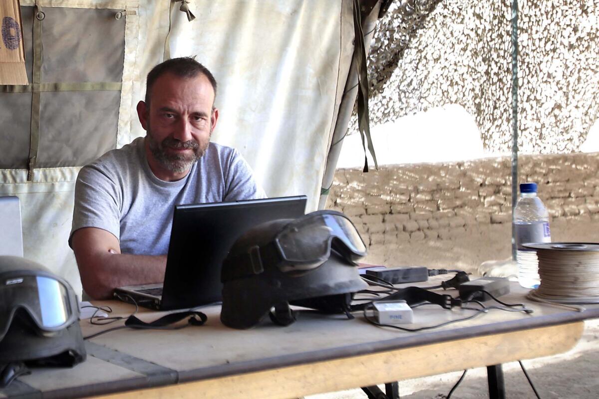 In this file photo released by the Spanish newspaper El Periodico on Sunday, journalist Marc Marginedas, who works for the paper, sits at his laptop computer at a Canadian base in Nakhonay, Afganistan, in 2010. Marginedas, who was kidnapped by Al Qaeda-linked militants in Syria, crossed the border into Turkey on Sunday, his newspaper reported.