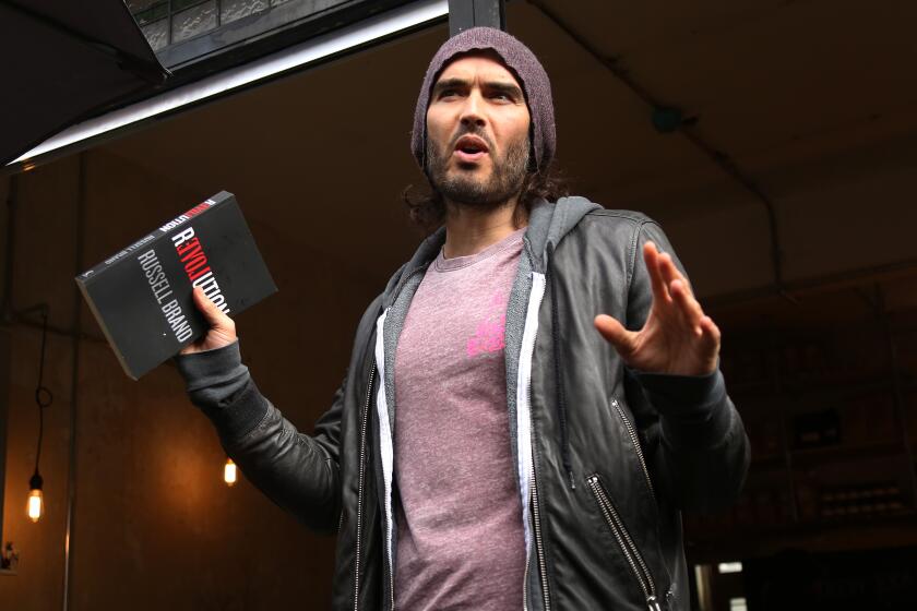 Russell Brand speaks at the opening of The Trew Era Cafe, a social enterprise community project on the New Era estate in east London, Thursday, 26 March, 2015. The opening of the cafe coincides with the trade paperback publication date of 'Revolution', and Brand will be donating 100% of his money for the book to the Cafe.(Photo by Joel Ryan/Invision/AP)