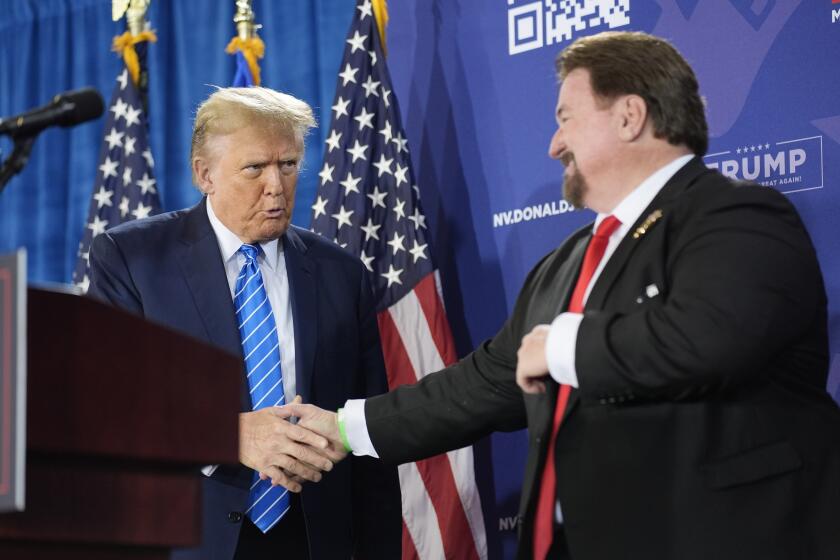 FILE - Nevada GOP chair Michael McDonald, right, shakes hands with Republican presidential candidate former President Donald Trump at a campaign event, Jan. 27, 2024, in Las Vegas. A Nevada state court judge dismissed a criminal indictment Friday, June 21, 2024, against six Republicans accused of submitting certificates to Congress falsely declaring Donald Trump the winner of the state’s 2020 presidential election. (AP Photo/John Locher, File)