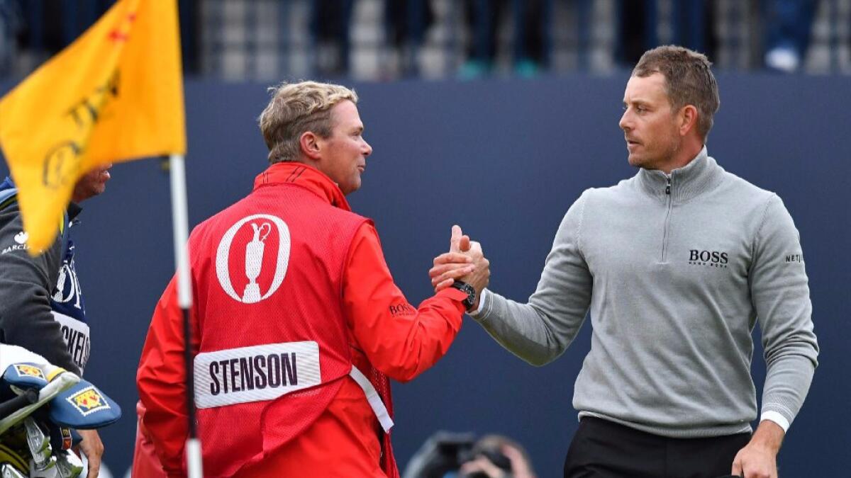 Henrik Stenson of Sweden shakes hands with his caddie Gareth Lord on the 18th green after completing his third round of the British Open Golf Championship.