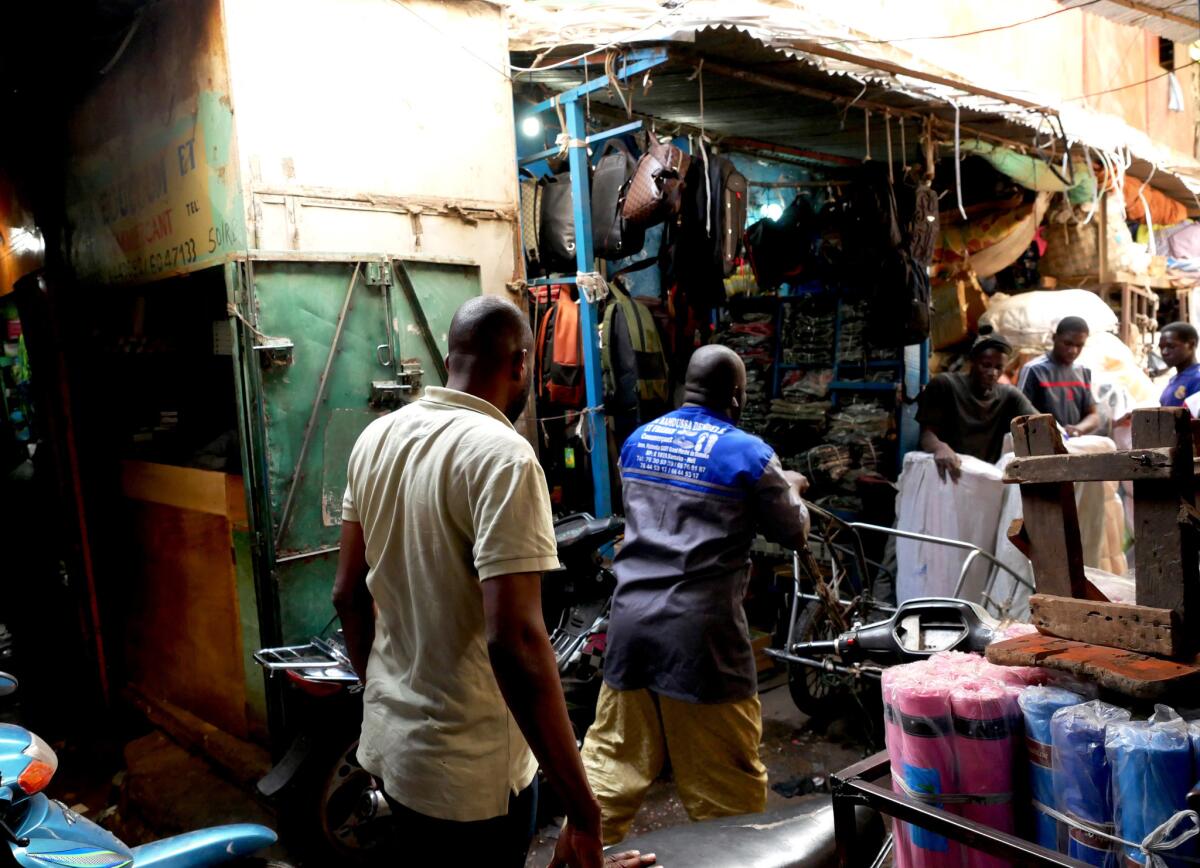 Trader Ibrahim Traoré walks through the Dabanani market. Lenali, a voice-based social media network available in multiple West African languages, is helping illiterate merchants reach more customers.