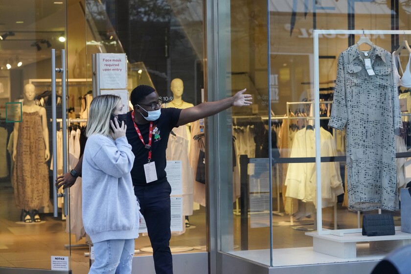 A salesperson gives directions to a shopper amid the COVID-19 pandemic on The Promenade Wednesday, June 9, 2021, in Santa Monica, Calif. (AP Photo/Marcio Jose Sanchez)
