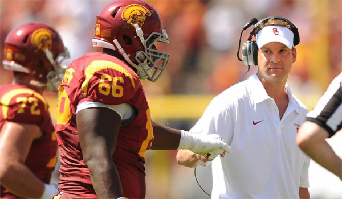 USC Coach Lane Kiffin fist bumps Marcus Martin after a Trojan touchdown against Boston College on Saturday.