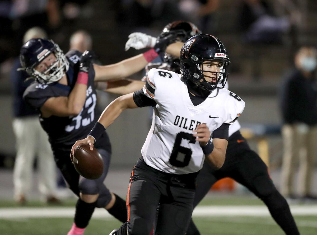 Huntington Beach quarterback AJ Perez takes off running after being chased from the pocket against Newport Harbor.