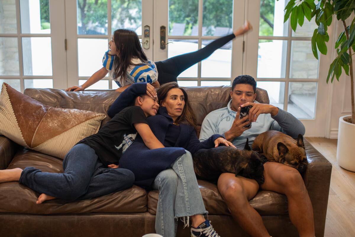 Zach Charbonnet, mother Seda Hall, sisters Bella and Athena and two dogs in a living room.