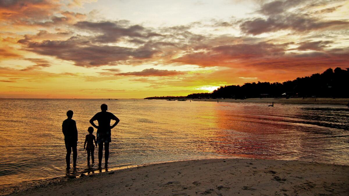 A family watches a sunset at Bantayan Island in northern Cebu province in the Philippines.