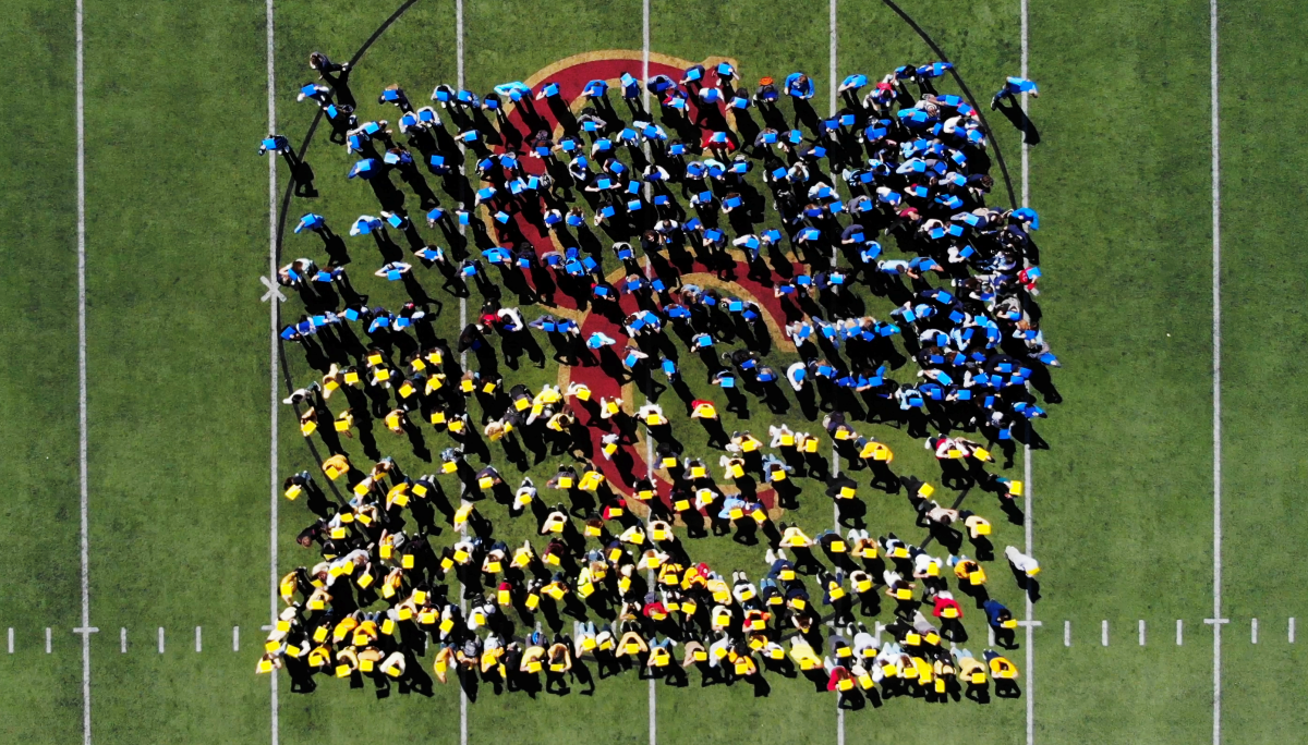 Students at Cathedral Catholic High School form a human Ukrainian flag at Manchester Stadium on March 16, 2022.