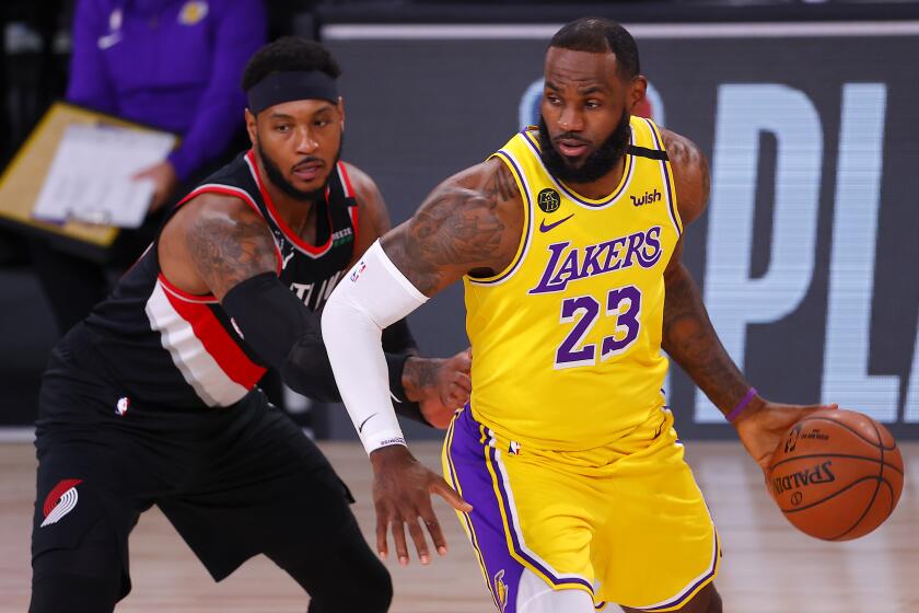 LeBron James, right, of the Los Angeles Lakers drives the ball against Carmelo Anthony, left, of the Portland Trail Blazers during the first half of Game 1 of an NBA basketball first-round playoff series, Tuesday, Aug. 18, 2020, in Lake Buena Vista, Fla. (Mike Ehrmann/Pool Photo via AP)