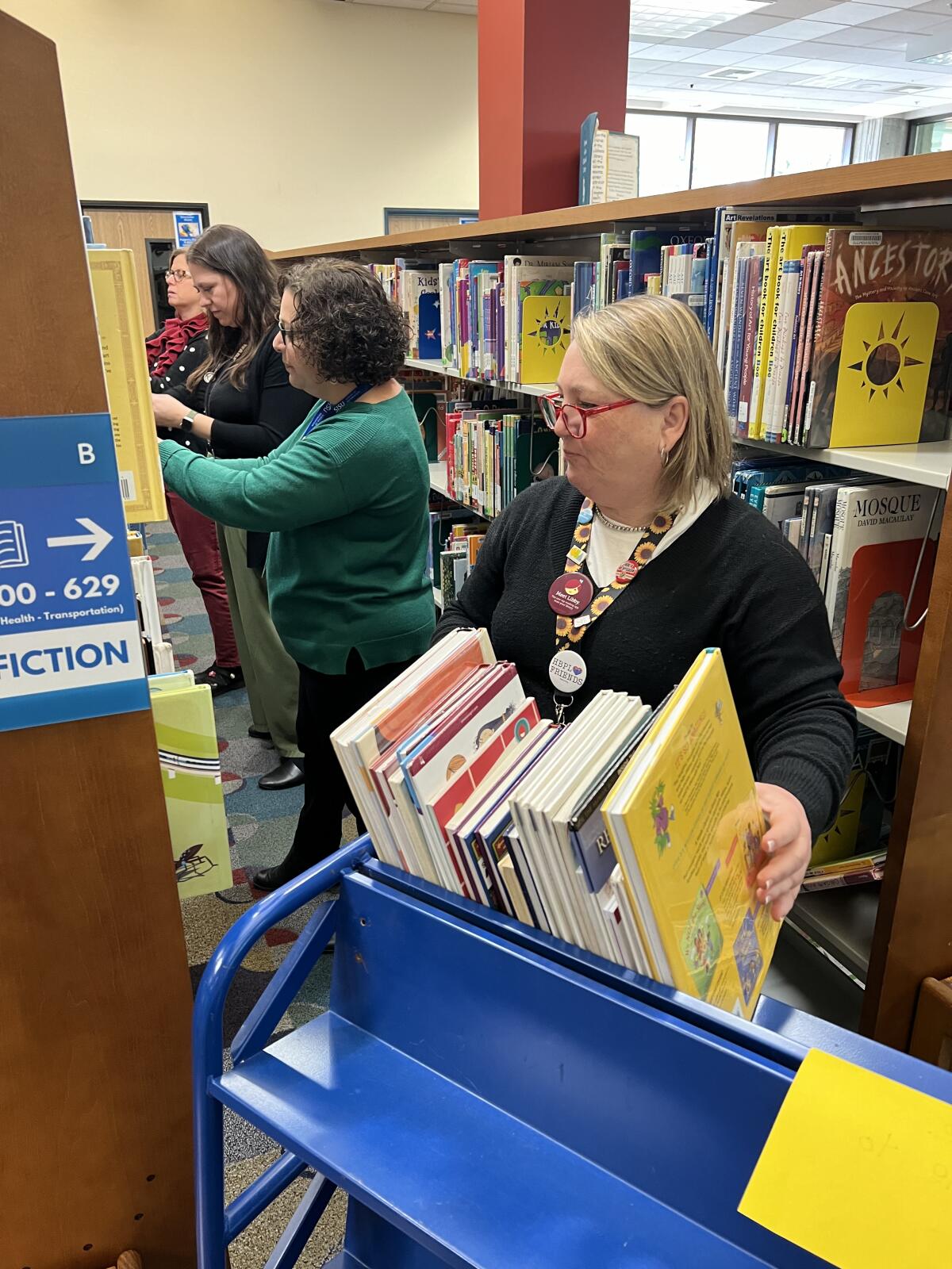 Librarians take books off the shelves for possible recategorization.