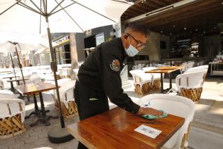 SANTA MONICA, CA - MAY 04: Antonio Espinoza sanitizes tables at Casa Martin Authentic Mexican restaurant on the Third Street Promenade in Santa Monica on Tuesday May 4, 2021 as Los Angeles County continues to rebound dramatically from a deadly winter COVID-19 surge, and with vaccinations continuing at a rapid pace there's increasing certainty that public health officials will move the county (and its many businesses, large and small) into the state's least restrictive reopening tier this week. Third Street Promenade on Tuesday, May 4, 2021 in Santa Monica, CA. (Al Seib / Los Angeles Times).