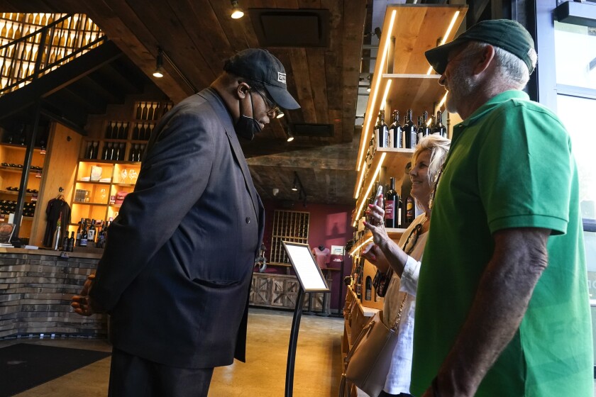 Customers entering a restaurant are greeted by a security officer.