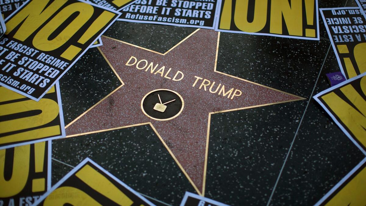 The Hollywood Walk of Fame star for Donald Trump is framed by protest signs on Dec. 25, 2016.