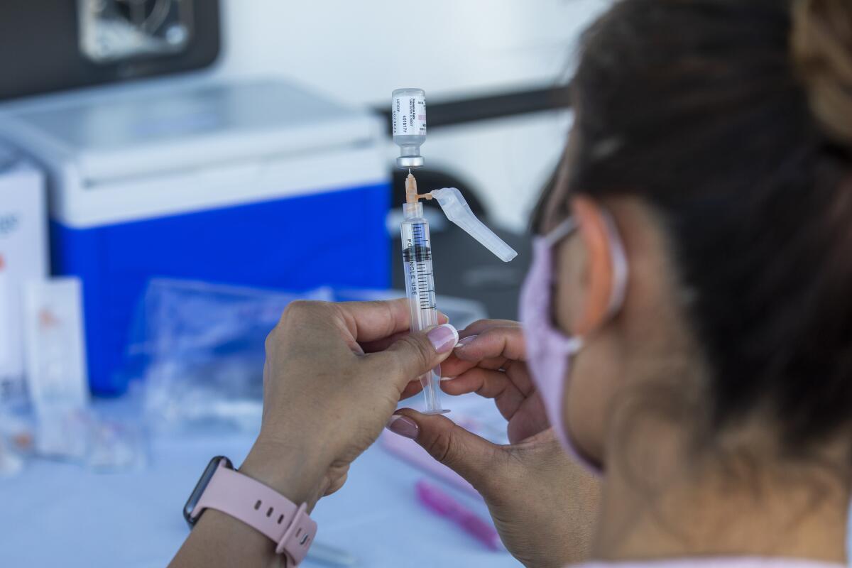 A worker prepares a COVID-19 vaccine 