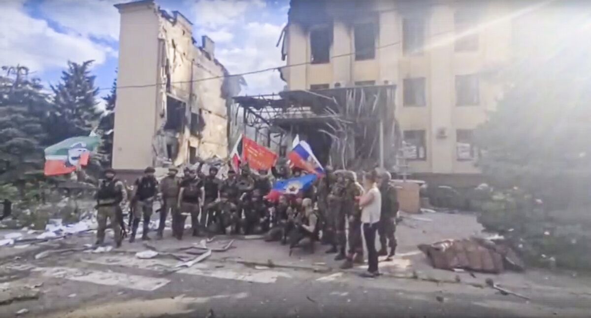 Russian troops waving Russian and Chechen republic national flags in Lysychansk, Ukraine.