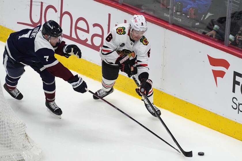 Colorado Avalanche defenseman Devon Toews, left, reaches for the puck with Chicago Blackhawks center Ryan Donato in the first period of an NHL hockey game, Monday, March 4, 2024, in Denver. (AP Photo/David Zalubowski)