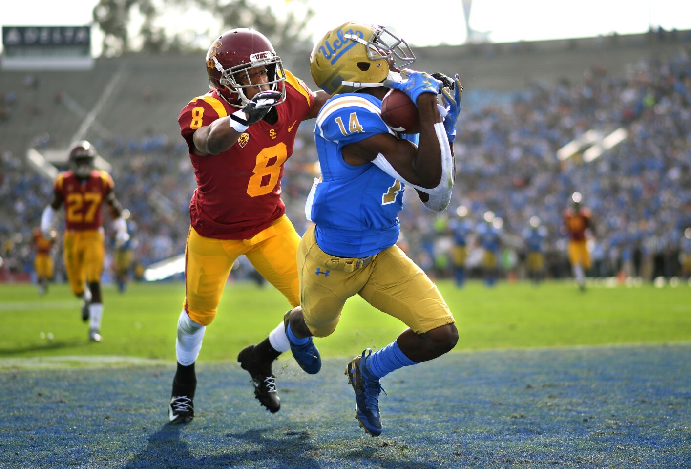 UCLA receiver Theo Howard catches a touchdown pass in front of USC defensive back Iman Marshall during the first quarter Saturday at the Rose Bowl.
