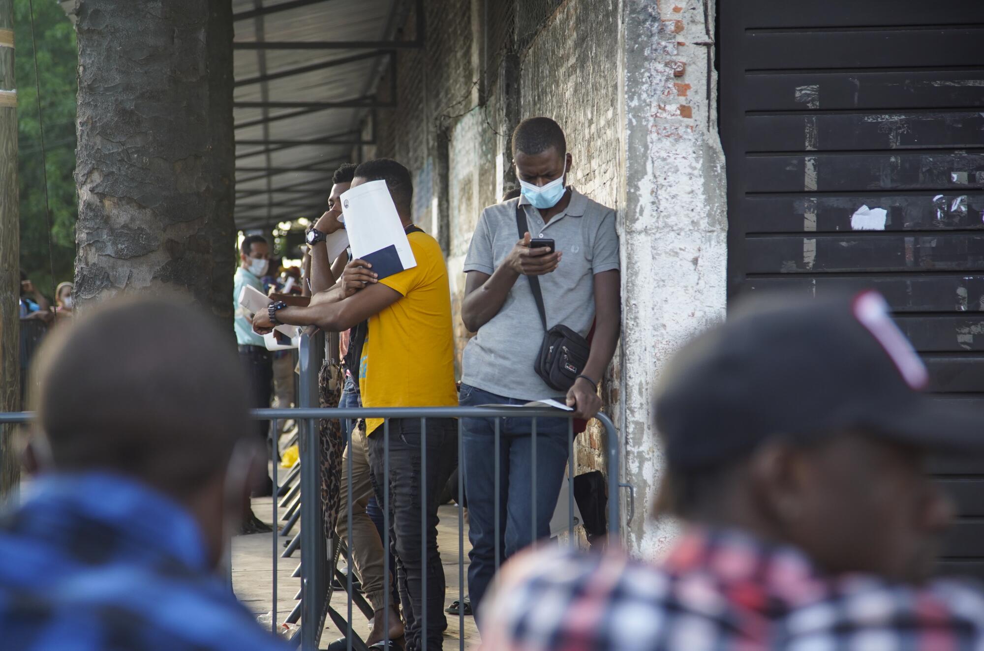 Asylum seekers wait in line outside a Tapachula office responsible for identifying refugees. 