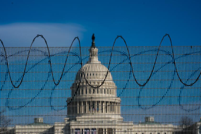 WASHINGTON, DC - JANUARY 21: Fencing and razor wire is still up around the U.S. Capitol complex as seen from the National Mall on Thursday, Jan. 21, 2021 in Washington, DC, a day after President Joe Biden was inaugurated. (Kent Nishimura / Los Angeles Times)