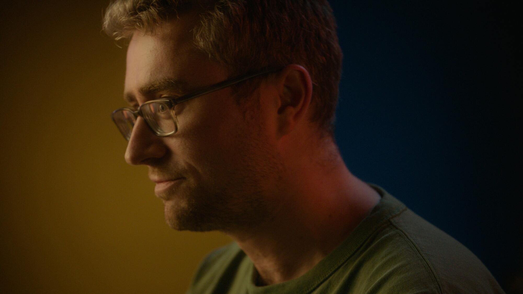 A close-up, profile shot of Kyle Sullivan, a blond man in glasses. 
